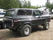 1979 Ford Bronco - This Ford Bronco is parked outdoors with trees and RVs visible in the background.