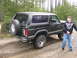 1979 Ford Bronco - This black 1979 Ford Bronco is seen from the rear three-quarter angle, parked on a dirt road.