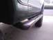 1978 Ford Bronco - A close-up shot focuses on the side step and exhaust pipe of a vehicle parked outdoors.