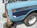 1994 Ford Bronco - Close-up of a dented blue pickup truck's rear quarter panel, showing a '1988 Scout' sticker.
