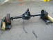1994 Ford Bronco - Rear axle assembly with drum brakes, resting on dollies outdoors.