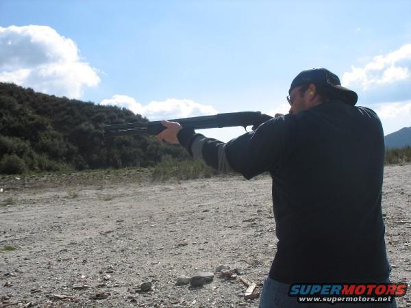 Man aiming a shotgun outdoors
