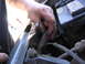 1987 Ford Bronco - A hand works on the wiring harness in the engine bay of a 1987 Ford Bronco.