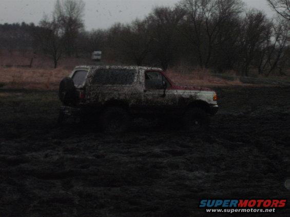 Mud-covered 1991 Ford Bronco stuck in mud, side view
