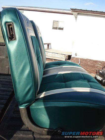 Green and gray tufted car seat with chrome trim, seen from the side