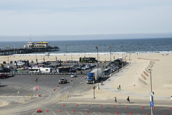 Parking lot full of cars near a beach and pier