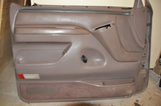 Brown interior door panel with armrest and storage pocket