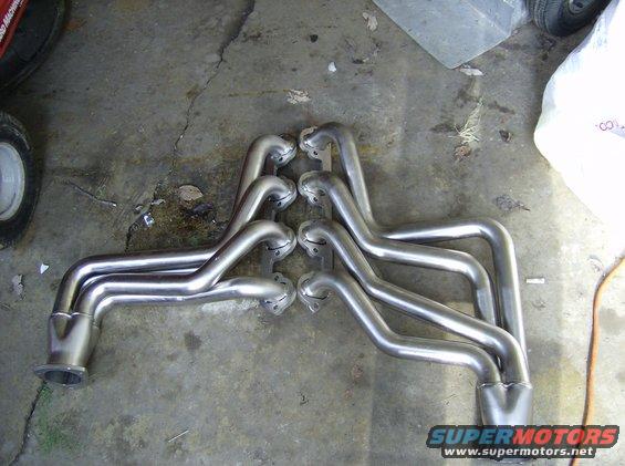 Pair of chrome exhaust headers on a concrete floor