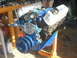 1982 Ford Bronco - A blue V8 engine is mounted on an orange stand, ready for installation or repair.