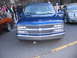 2001 Chevrolet Silverado 1500 - A blue 2001 Chevrolet Silverado 1500 is parked with its door open, showing a custom hood graphic and chrome grille.