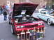 2001 Chevrolet Silverado 1500 - Customized red car with engine exposed and trophies in front, parked next to a vintage sedan.