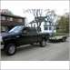 2005 Ford F-250 - Black 2005 Ford F-250 Super Duty pickup truck is seen from the side, towing a trailer.