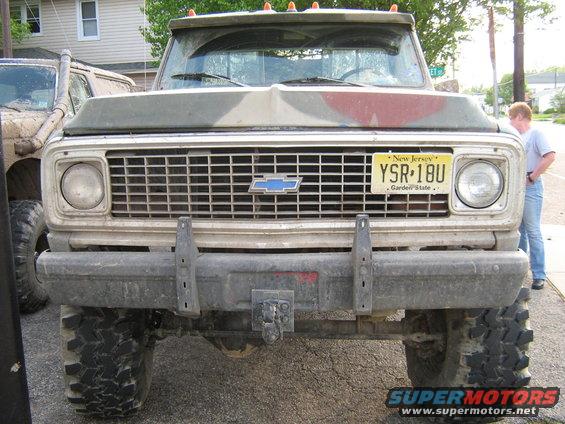 Front view of a weathered Chevrolet truck with a New Jersey license plate YSR-18U. Another off-road vehicle is partially visible to the left