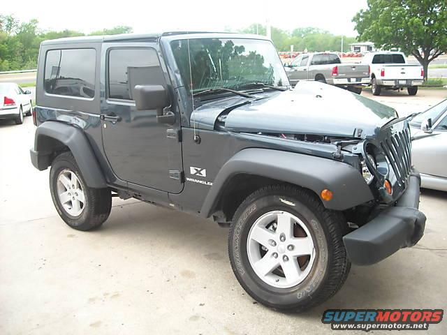 Dark gray Jeep Wrangler with hood open and front end damage