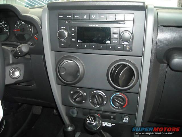 Jeep Wrangler JK interior showing dashboard, radio, air vents, and gear shifter