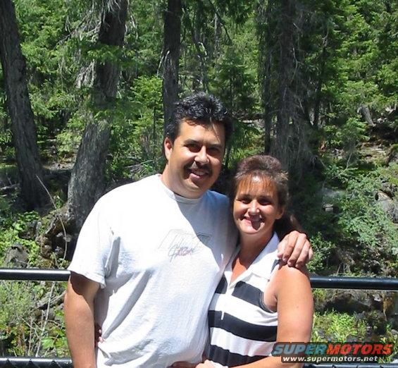 Couple posing for a photo in a wooded area