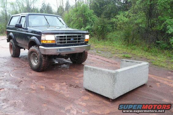 Black 1995 Ford Bronco with lifted suspension parked on a muddy road