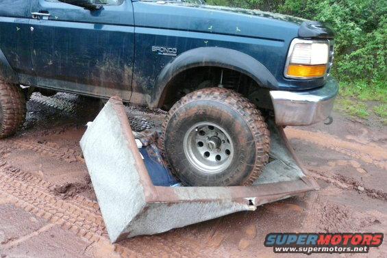 1995 Ford Bronco front passenger side tire on a couch cushion in mud