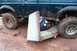 1995 Ford Bronco - A Ford Bronco is stuck in the mud, with a piece of a couch wedged underneath it.