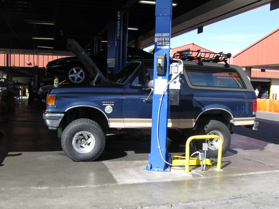 Blue 1986 Ford Bronco on a car lift, front 3/4 view