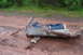1995 Ford Bronco - Discarded car door panel on a dirt road, showing damage and exposed interior materials.