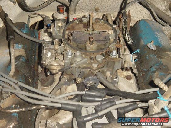 Engine bay detail showing a carburetor and spark plug wires