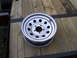 2005 Ford F-250 - A single steel wheel is placed on a wooden trailer. The wheel has a silver finish and multiple circular cutouts.