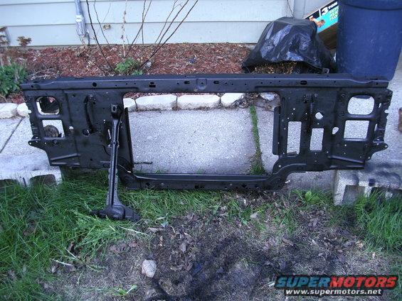 Black metal radiator support assembly lying on grass