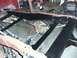 1994 Ford F-250 - The rear suspension and frame of a red truck are visible, appearing to be in a state of repair.