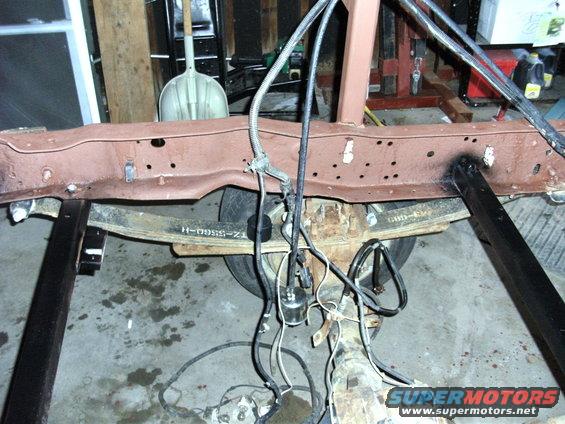 Truck frame with leaf springs and brake lines visible