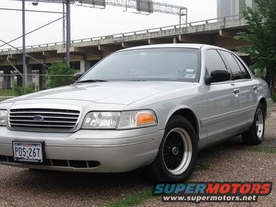 1998 Ford Crown Victoria with black aftermarket wheels and a license plate reading PDS-267