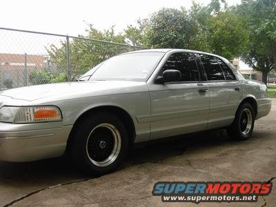 Silver sedan parked outside, side view. Has black rims and tinted windows
