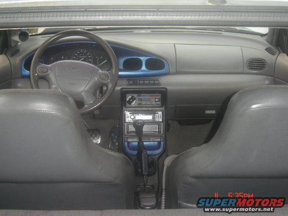 Interior shot of a car, showing the dashboard, steering wheel, center console with gear shifter, and front seats