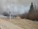 1996 Dodge 2500 - A firefighter battles a grass fire, with thick smoke billowing into the sky. A signpost stands nearby.