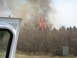1996 Dodge 2500 - A wildfire rages in a wooded area, with flames and smoke visible against the sky.