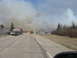 1996 Dodge 2500 - Emergency vehicles are on scene responding to a wildfire that is burning near a wooded area.