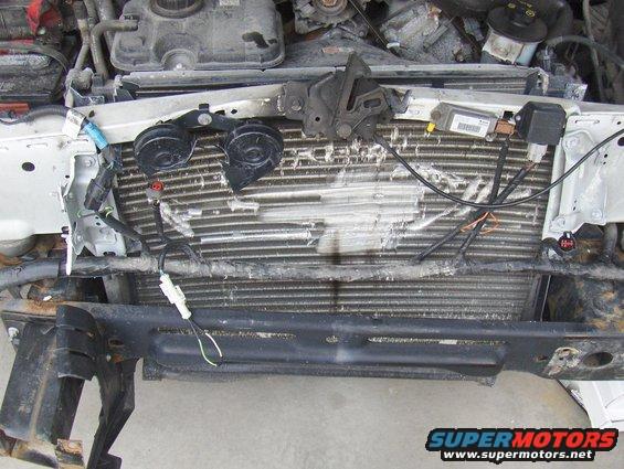 2003 Ford Crown Victoria front engine bay with damaged radiator and exposed wiring