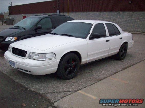 2003 Ford Crown Victoria parked next to a black minivan