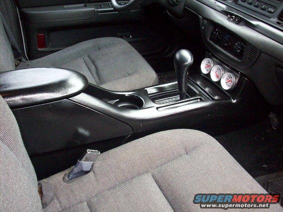2003 Ford Crown Victoria interior showing center console with gear shifter and three aftermarket gauges