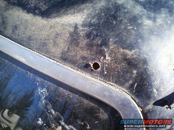 Black hood with two rust holes and chrome trim