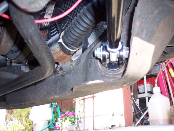 Close-up of a suspension component with a ribbed hose and fan belts