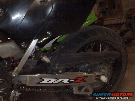 Close-up of a motorcycle's rear swingarm with 'DR-Z' graphics and a spoked wheel