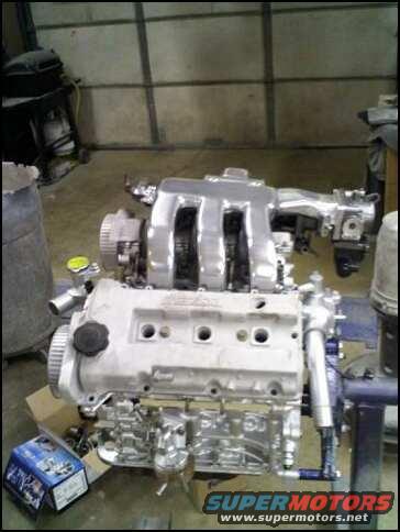 engine assembly on stand, box of parts on floor