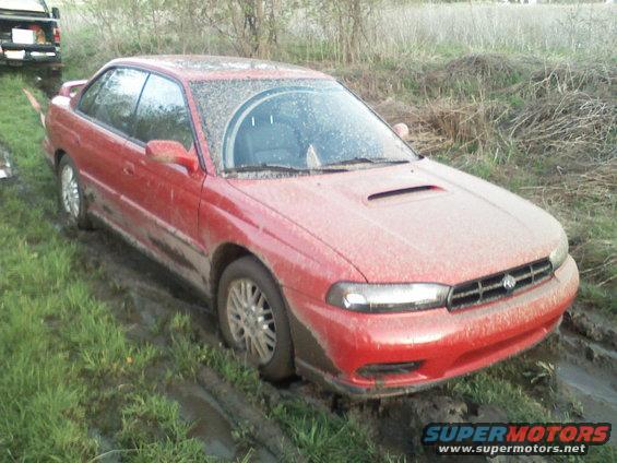 Red 1997 Subaru Legacy coupe stuck in mud, front view