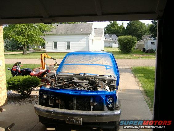 1992 Dodge Dakota pickup truck with hood open, engine exposed, front end covered in blue plastic sheeting, parked in driveway