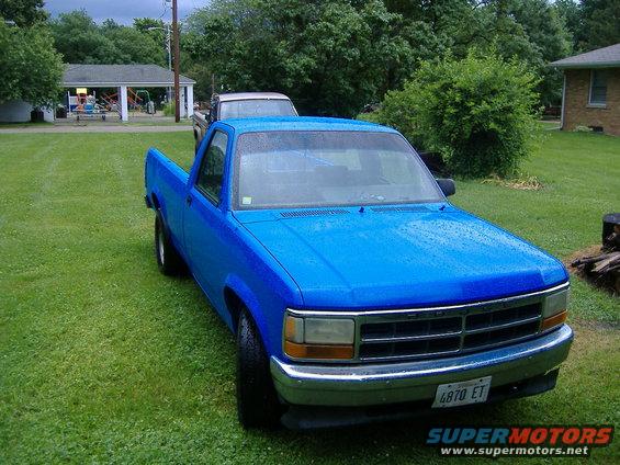 Blue pickup truck with a chrome grille and bumper, parked on grass. License plate reads 6870 ET