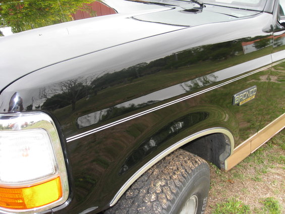 1994 Ford Bronco fender with chrome trim and a "Bronco" badge, showing the front tire