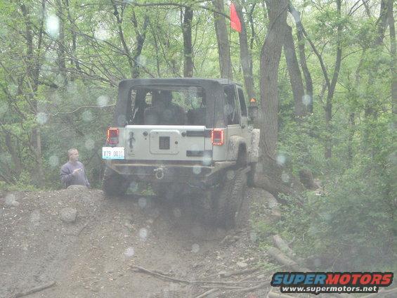 Rear view of a Jeep Wrangler on a muddy trail