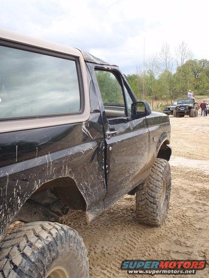 Black 1996 Ford Bronco, 3/4 front view, lifted with large tires on sandy terrain