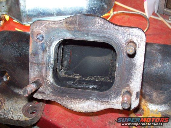 Exhaust manifold with internal carbon buildup and visible weld marks
